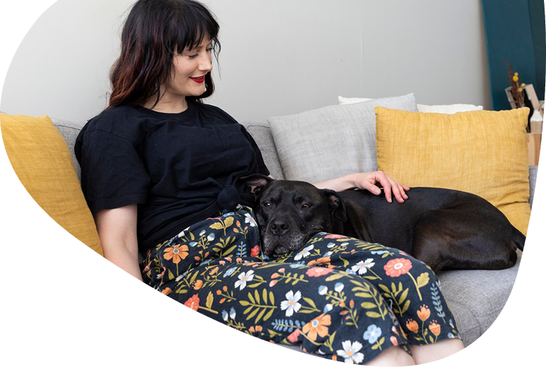 Pets are family. Black dog resting on owners lap.